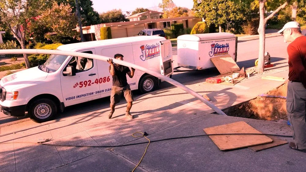 Two J Drains trucks at a job site.