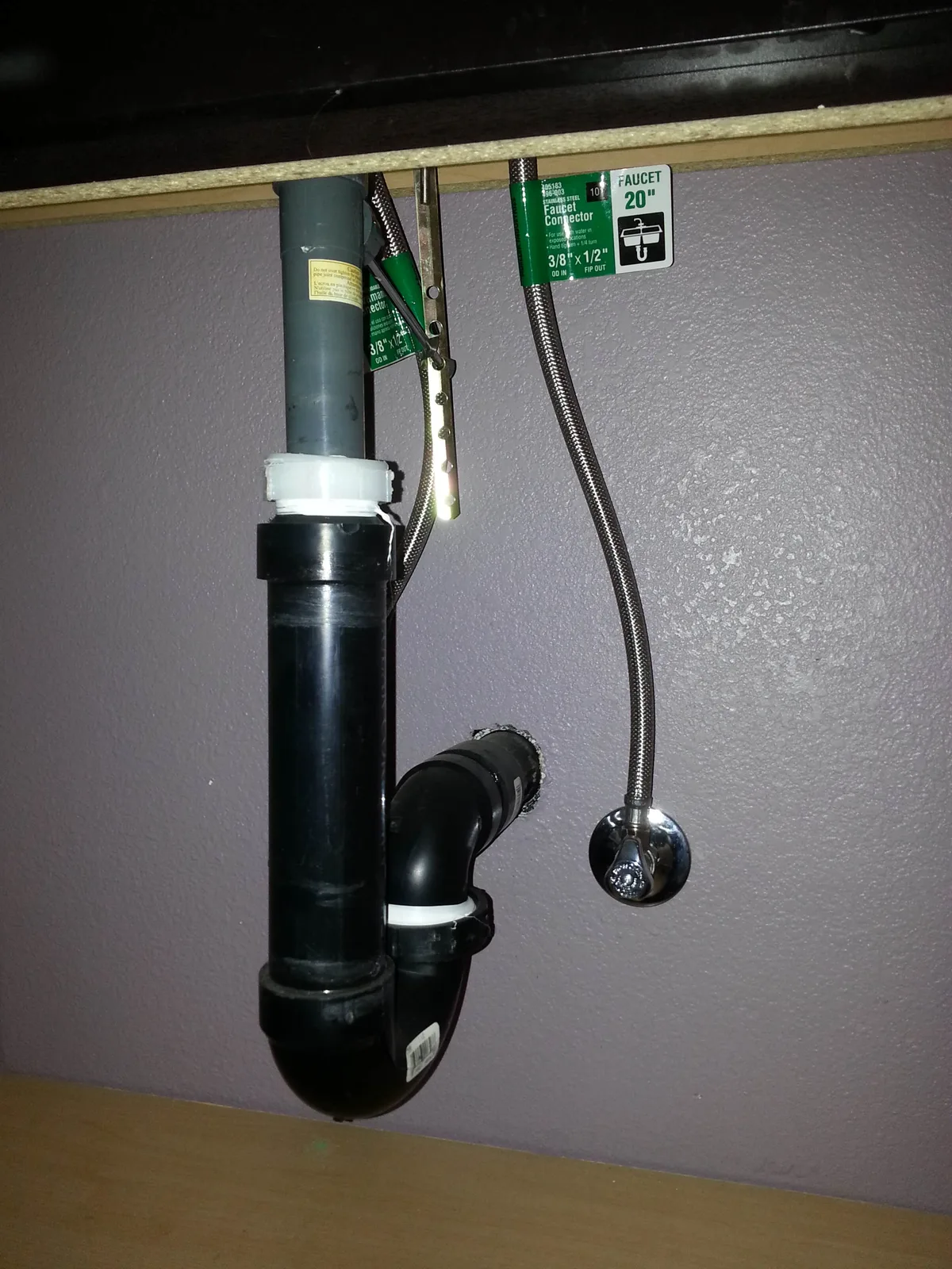 A finished trap and shutoffs under a sink.